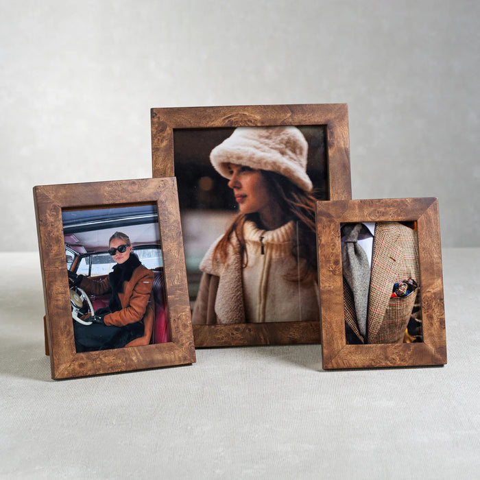 The ZODAX BURL WOOD PHOTO FRAME 5X7 displays a photo of a person in sunglasses and a brown coat seated in a car, standing elegantly against a white background.