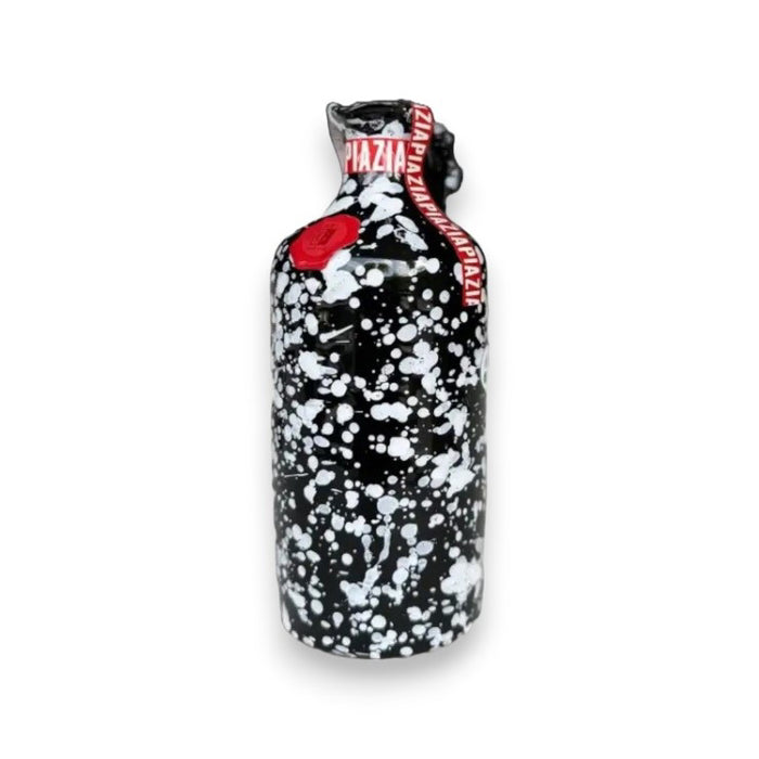 A black bottle of GALANTINO - EXTRA VIRGIN OLIVE OIL LIMITED EDITION by ZIA PIA IMPORTS features a white paint splatter design, red wax seal, and red band with white text. Inspired by Puglia, Italy. Plain white background.