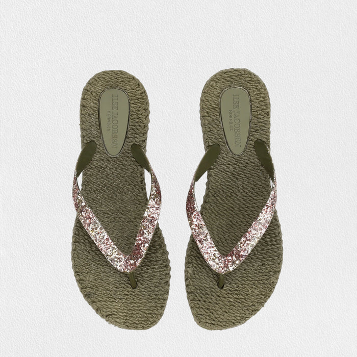 The ILSE JACOBSEN CHEERFUL FLIP FLOPS IN ARMY GLITTER by LINES OF DENMARK feature thick, braided olive green soles and dark green glitter thong straps with a pink glittery accent, shown on a light textured background.