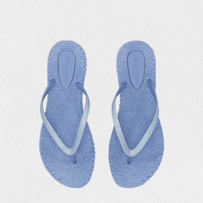 The ILSE JACOBSEN CHEERFUL SLIPPER IN LIGHT REGATTA by LINES OF DENMARK features lightweight, light blue flip flops with woven square soles and thin straps, shown on a plain white background.