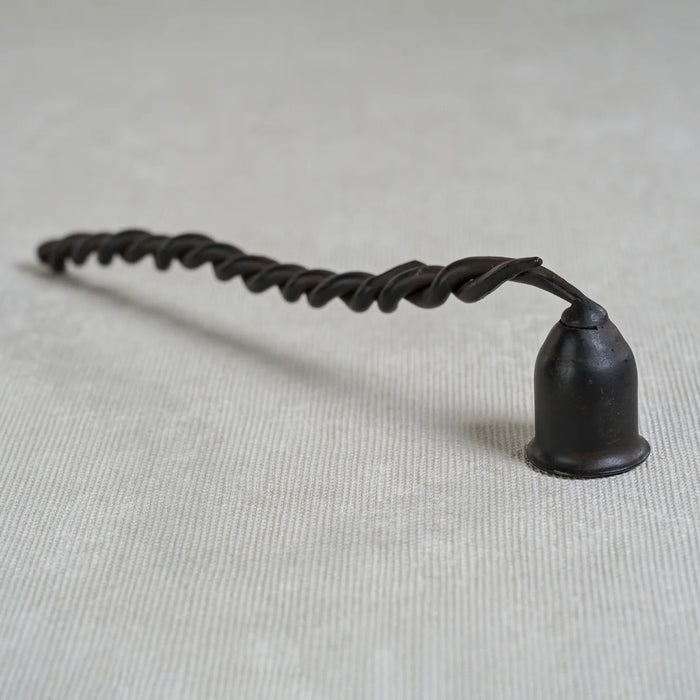 The ZODAX TWISTED WROUGHT IRON CANDLE SNUFFER features a black, spiral handle and a small, cup-shaped snuffer at one end, shown isolated on a white background.