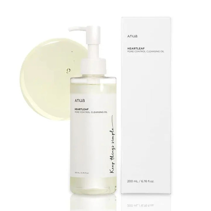 A clear pump bottle of ANUA - PORE CLEANSING OIL HEARTLEAF OIL WASH 200ML by ASIAN BEAUTY WHOLESALE is displayed beside its white box, with a small pool of light yellow cleansing oil visible in the background.