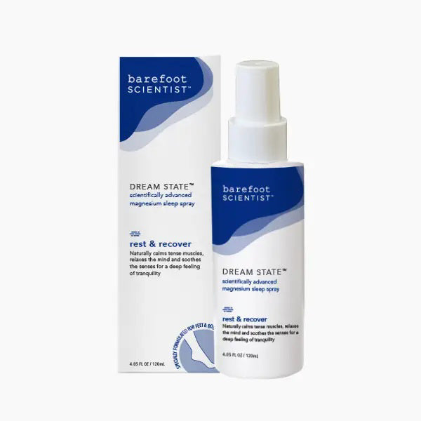 A bottle and box of BAREFOOT SCIENTIST - DREAM STATE MAGNESIUM SLEEP SPRAY, labeled "rest & recover," soothe muscles and support sleep with magnesium and ashwagandha. Both feature a calming blue and white design.