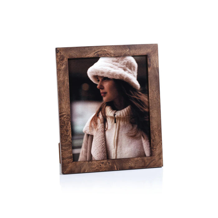 The ZODAX BURL WOOD PHOTO FRAME 8X10 showcases a portrait of a woman in a white fuzzy hat and cream coat, gazing sideways against a softly blurred backdrop.