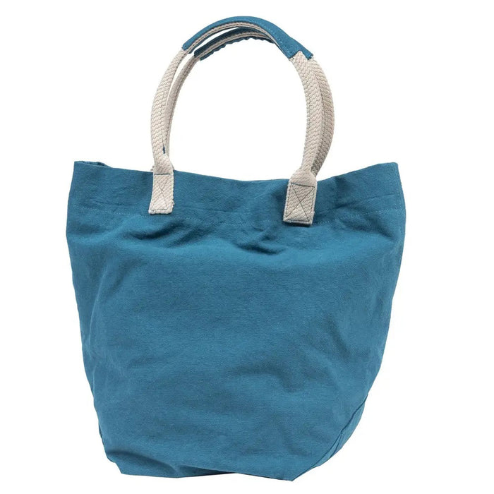 The TRAVAUX EN COURS CANVAS TOTE BAG is a versatile teal accessory with beige 100% cotton canvas handles. It features a spacious main compartment, with securely stitched handles ideal for carrying by hand or over the shoulder.
