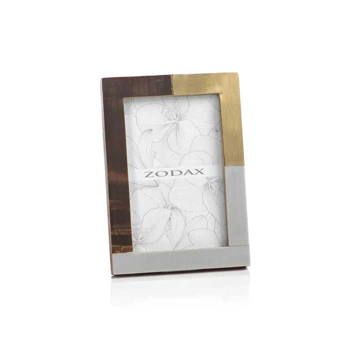 The ZODAX CAPE TOWN PHOTO FRAME - 4X6 features a modern rectangular design with brown wood, gold, and silver metal sections. This upright glass frame displays floral line art and the "ZODAX" logo.