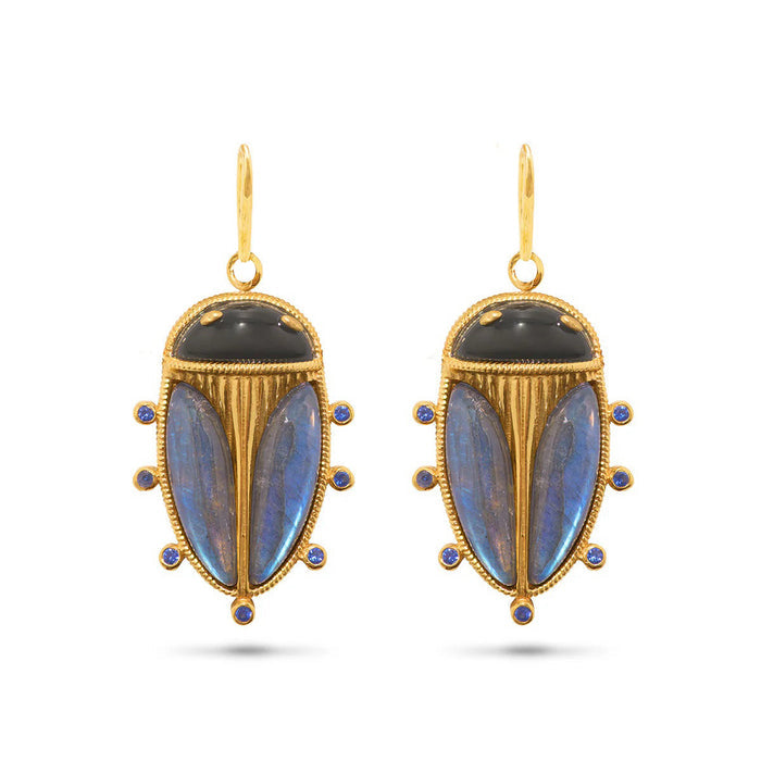 The CAPUCINE DE WULF Scarab Petite Drop Blue Labradorite/Black Agate Earrings feature beetle-inspired designs with black and blue stones and six blue gems—unique statement jewelry for a striking look.
