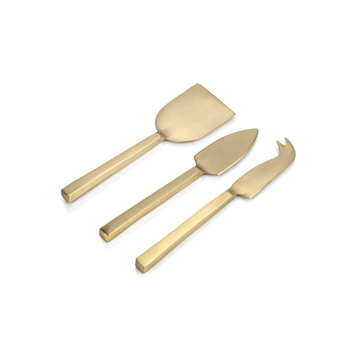 The ZODAX CHEESE SLICER AND SERVER SET, featuring gold spade and chisel knives with round cheese wedges, is displayed on a marble board atop a gray textured surface, with a wooden cheese box partially visible behind it.