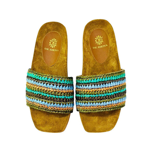 The DA SIENA - LUCILLA RAFIA SLIDE by DE SIENA features open-toe sandals with brown suede soles, a comfy eco footbed, wide multicolored woven straps in green, blue, yellow, and brown stripes, and a branded floral "DE SIENA" insole.