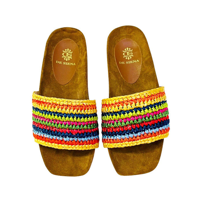 The DA SIENA - LUCILLA RAFIA SLIDE by DE SIENA features open-toe sandals with brown suede soles, a comfy eco footbed, wide multicolored woven straps in green, blue, yellow, and brown stripes, and a branded floral "DE SIENA" insole.
