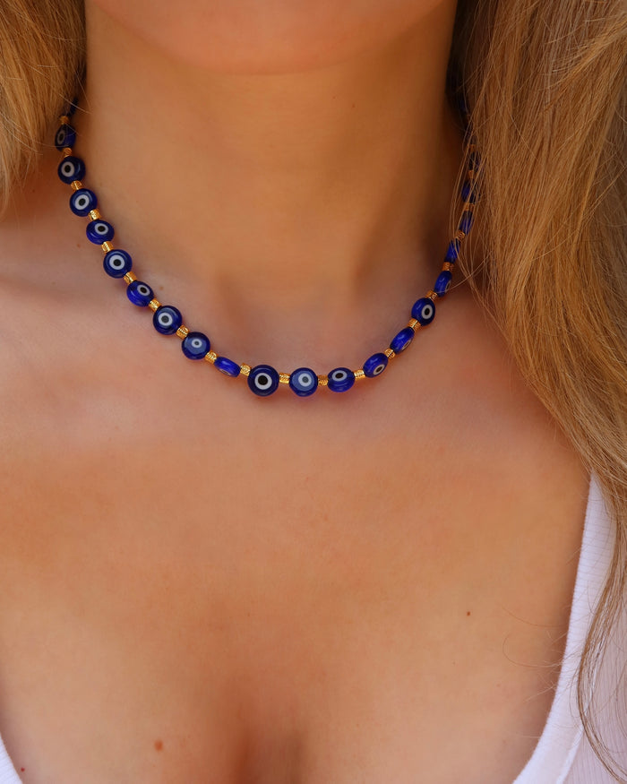 Woman wearing a blue glass evil eye choker necklace made in Greece, Greek jewelry