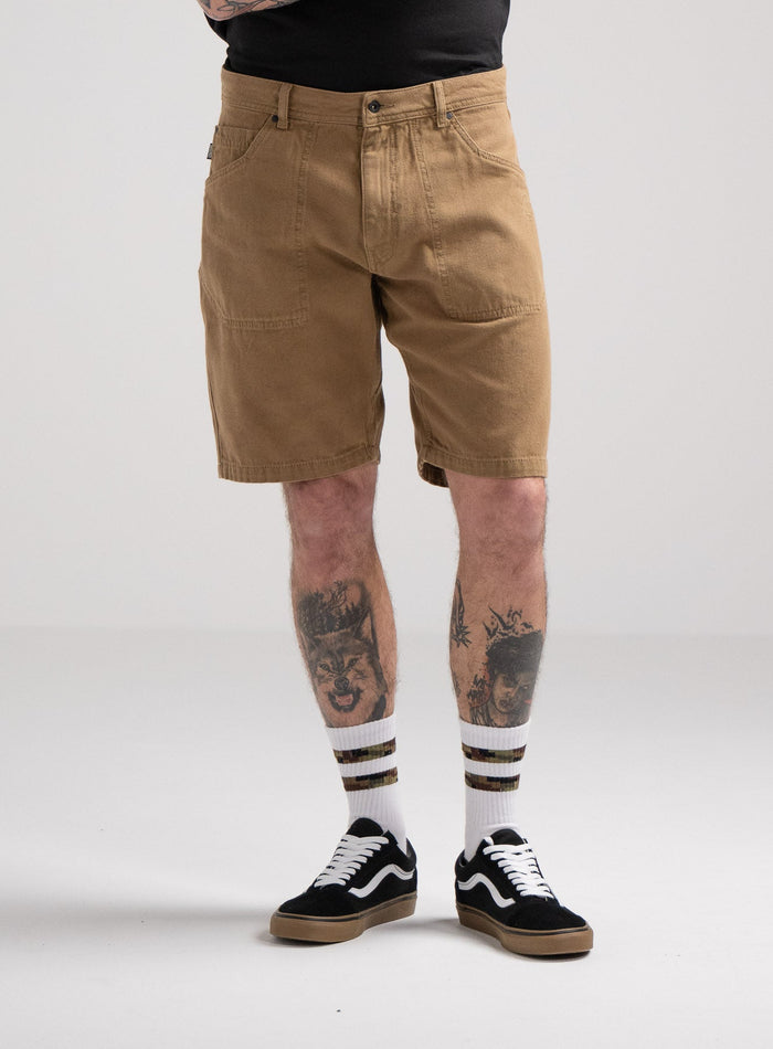 Bernie Is 6ft And Wears Size: M | Hem Studio Image Of Model Wearing Dissident Canvas Shorts In Coyote Brown (SS Model)