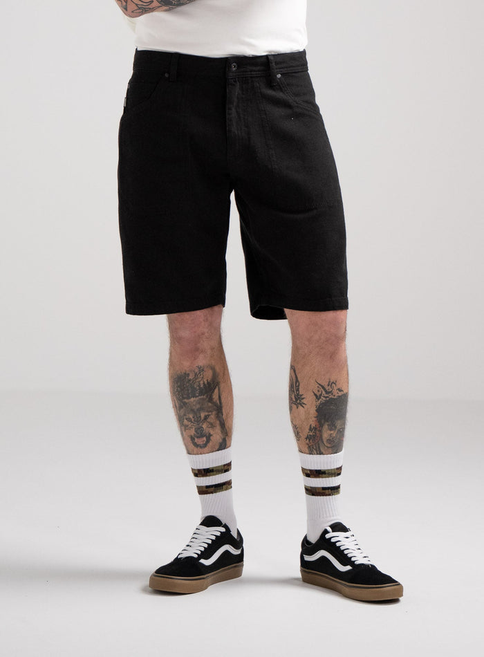 Bernie Is 6ft And Wears Size: M | Hem Studio Image Of Model Wearing Dissident Canvas Shorts In Obsidian Black (SS Model)