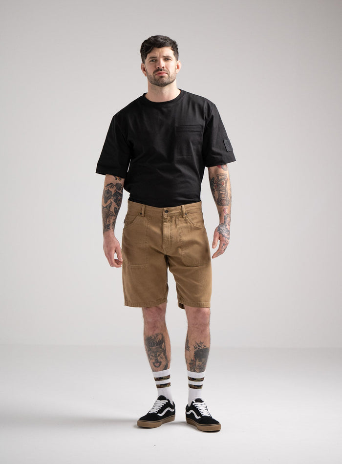 Bernie Is 6ft And Wears Size: M | Hem Studio Image Of Model Wearing Dissident Canvas Shorts In Coyote Brown (SS Model)