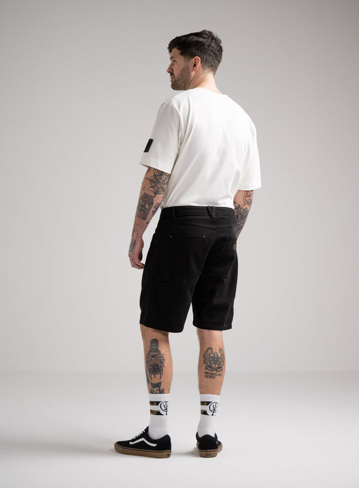 Bernie Is 6ft And Wears Size: M | Hem Studio Image Of Model Wearing Dissident Canvas Shorts In Obsidian Black (SS Model)