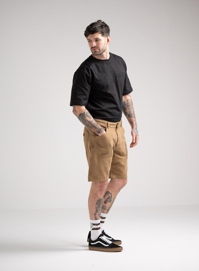 Bernie Is 6ft And Wears Size: M | Hem Studio Image Of Model Wearing Dissident Canvas Shorts In Coyote Brown (SS Model)
