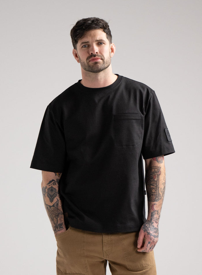 Bernie Is 6ft And Wears Size: M | Hem Studio Image Of Model Wearing Dissident Heavy T-Shirt In Obsidian Black (SS Model)
