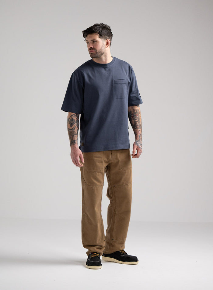 Bernie Is 6ft And Wears Size: M | Hem Studio Image Of Model Wearing Dissident Heavy T-Shirt In Storm Blue (SS Model)