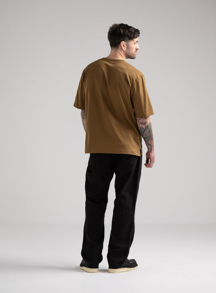 Bernie Is 6ft And Wears Size: M | Hem Studio Image Of Model Wearing Dissident Heavy T-Shirt In Coyote Brown (SS Model)