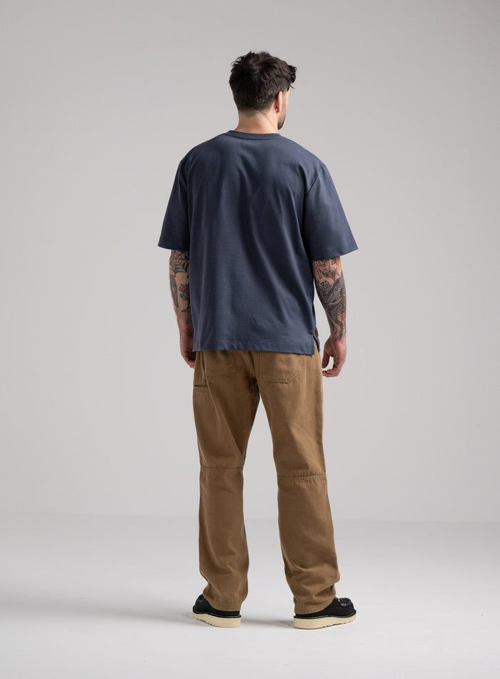 Bernie Is 6ft And Wears Size: M | Hem Studio Image Of Model Wearing Dissident Heavy T-Shirt In Storm Blue (SS Model)