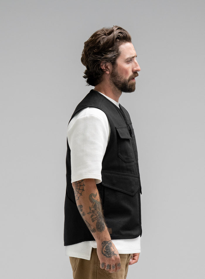 Max Is 5ft 8" And Wears Size: M | Hem Studio Image Of Model Wearing Dissident Utility Vest In Obsidian Black (SS Model)