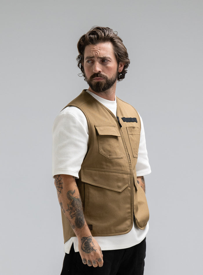 Max Is 5ft 8" And Wears Size: M | Hem Studio Image Of Model Wearing Dissident Utility Vest In Coyote Brown (SS Model)