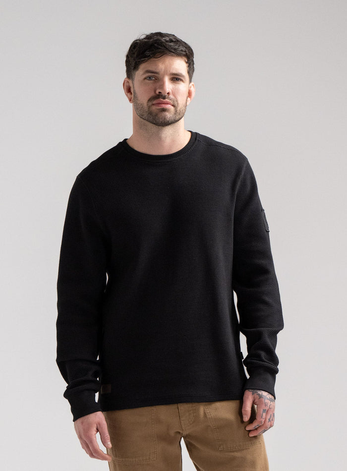 Bernie Is 6ft And Wears Size: M | Hem Studio Image Of Model Wearing Dissident Waffle Long Sleeve T-Shirt In Obsidian Black (SS Model)