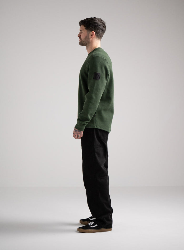 Bernie Is 6ft And Wears Size: M | Hem Studio Image Of Model Wearing Dissident Waffle Long Sleeve T-Shirt In Forest Green (SS Model)