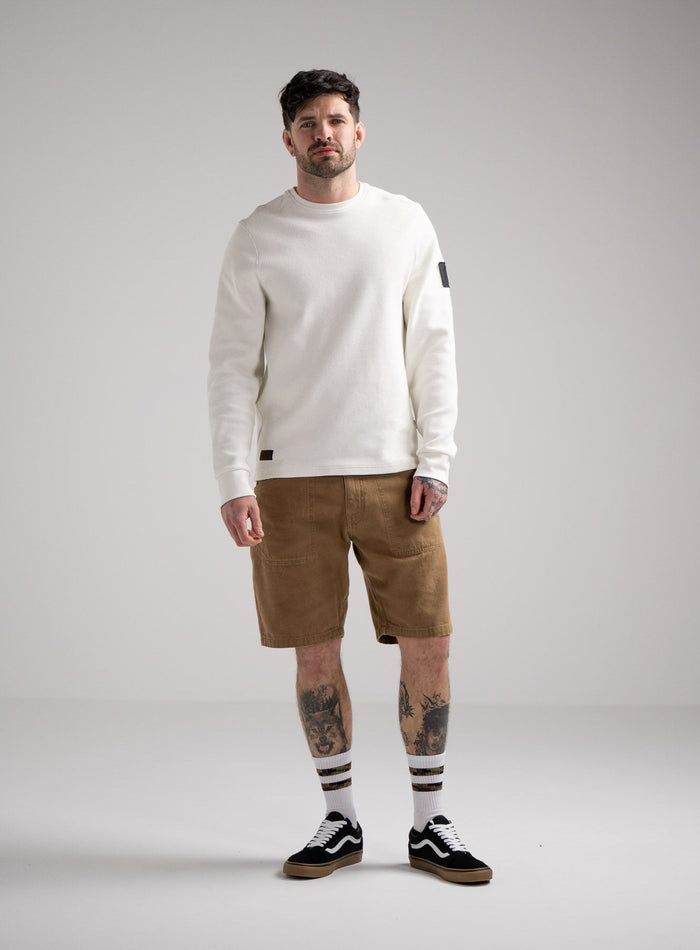 Bernie Is 6ft And Wears Size: M | Hem Studio Image Of Model Wearing Dissident Waffle Long Sleeve T-Shirt In Optic White (SS Model)