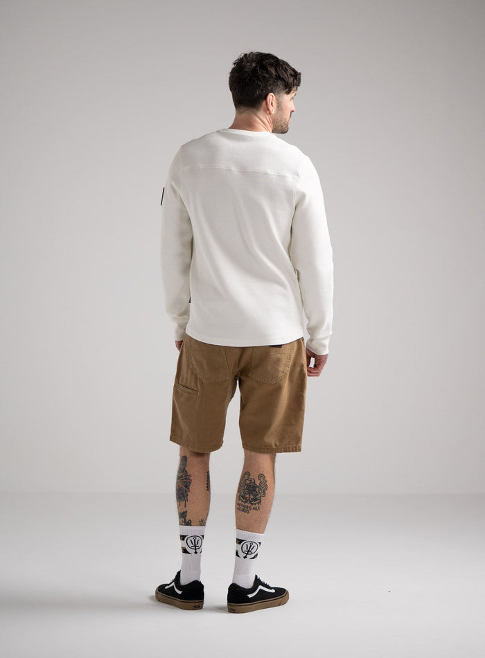 Bernie Is 6ft And Wears Size: M | Hem Studio Image Of Model Wearing Dissident Waffle Long Sleeve T-Shirt In Optic White (SS Model)