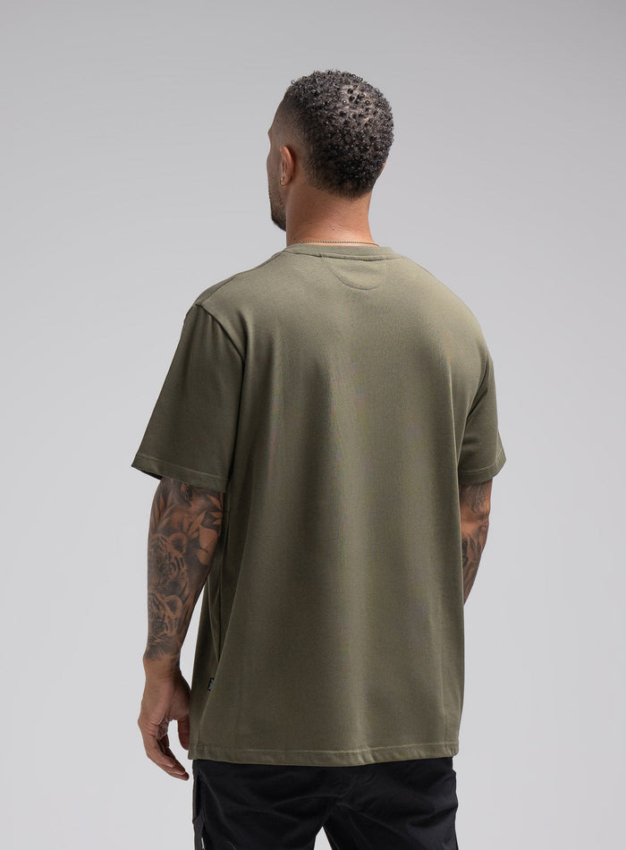 Dj Is 6ft 4" And Wears Size: Xl | Hem Studio Image Of Model Wearing Enigma Oversized Tee In Khaki (SS Model)