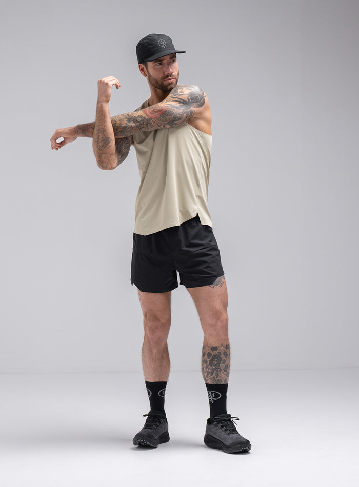 Chez Is 6ft And Wears Size: M | Hem Studio Image Of Model Wearing Force Trail Running Singlet In Stone (SS Model)