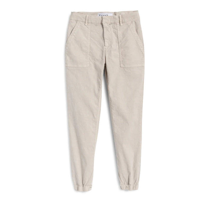 The FRANK & EILEEN JAMESON UTILITY JOGGER in Cement is a beige, high-rise jogger made from soft Italian Performance Linen, featuring a tapered ankle, two large front pockets, button-zip closure, and belt loops.