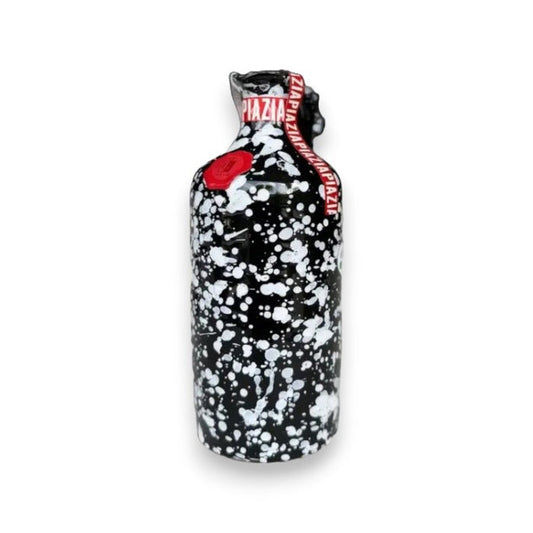 A black bottle of GALANTINO - EXTRA VIRGIN OLIVE OIL LIMITED EDITION by ZIA PIA IMPORTS features a white paint splatter design, red wax seal, and red band with white text. Inspired by Puglia, Italy. Plain white background.