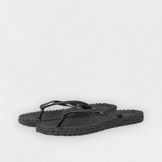 The ILSE JACOBSEN - CHEERFUL FLIP FLOP IN BLACK by LINES OF DENMARK features black braided-texture soles and simple black straps, displayed on a light textured background.
