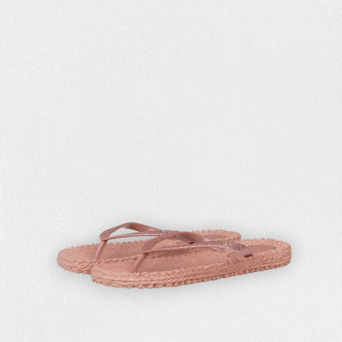 The ILSE JACOBSEN CHEERFUL FLIP FLOPS IN MISTY ROSE by LINES OF DENMARK feature slim plastic straps and braided straw-textured soles, showcased on a light, textured surface.