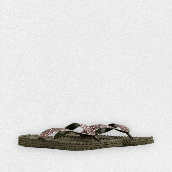 The ILSE JACOBSEN CHEERFUL FLIP FLOPS IN ARMY GLITTER by LINES OF DENMARK feature thick, braided olive green soles and dark green glitter thong straps with a pink glittery accent, shown on a light textured background.