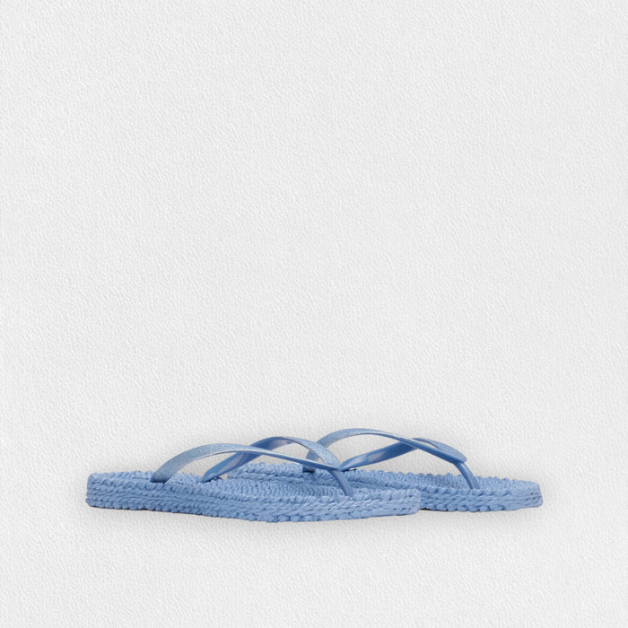 The ILSE JACOBSEN CHEERFUL SLIPPER IN LIGHT REGATTA by LINES OF DENMARK features lightweight, light blue flip flops with woven square soles and thin straps, shown on a plain white background.