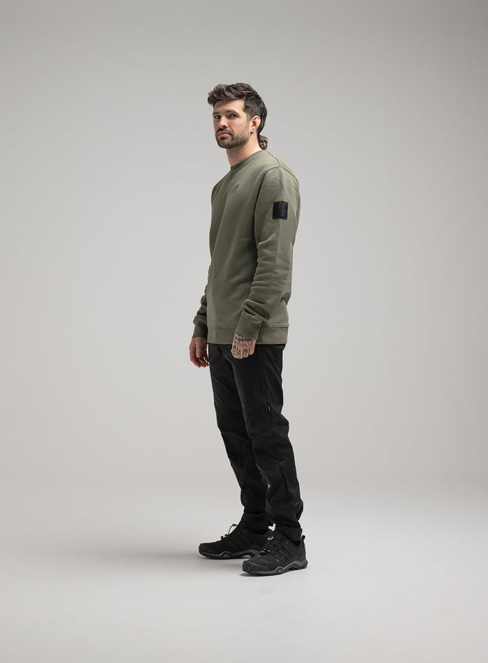 Bernie Is 6ft And Wears Size: M | Hem Studio Image Of Model Wearing Insignia Jumper Washed In Khaki (SS Model)