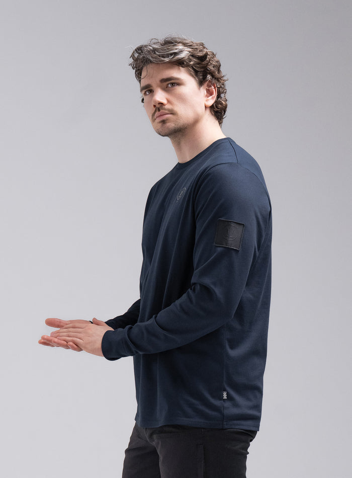 Jack Is 6ft 3" And Wears Size: L | Hem Studio Image Of Model Wearing Insignia Long Sleeve T-Shirt In Dark Sapphire (SS Model)
