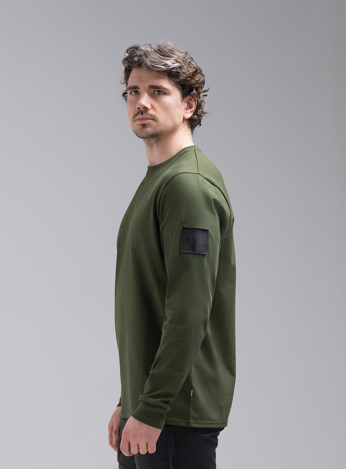 Jack Is 6ft 3" And Wears Size: L | Hem Studio Image Of Model Wearing Insignia Long Sleeve T-Shirt In Forest Green (SS Model)