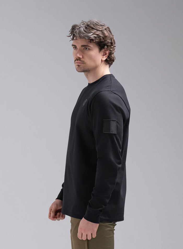 Jack Is 6ft 3" And Wears Size: L | Hem Studio Image Of Model Wearing Insignia Long Sleeve T-Shirt In Obsidian Black (SS Model)
