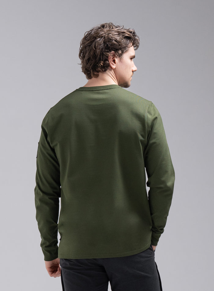 Jack Is 6ft 3" And Wears Size: L | Hem Studio Image Of Model Wearing Insignia Long Sleeve T-Shirt In Forest Green (SS Model)