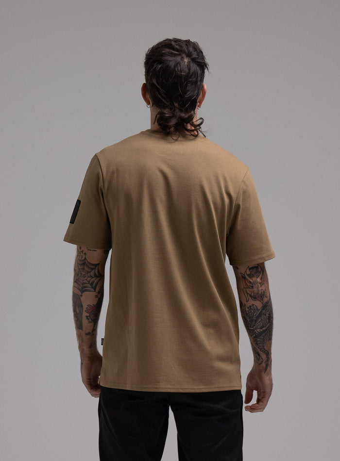 George Is 5ft 11" And Wears Size: S | Hem Studio Image Of Model Wearing Insignia T-Shirt G1 In Sand (SS Model)