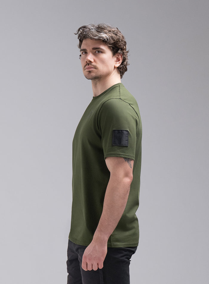 Jack Is 6ft 3" And Wears Size: L | Hem Studio Image Of Model Wearing Insignia Short Sleeve T-Shirt In Forest Green (SS Model)