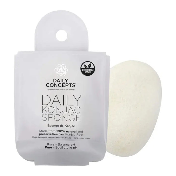 A package labeled "DAILY CONCEPTS KONJAC SPONGE - PURE" sits beside a white oval-shaped sponge. Inspired by Japanese rituals, this biodegradable, vegan konjac root sponge gently cleanses and balances skin pH.