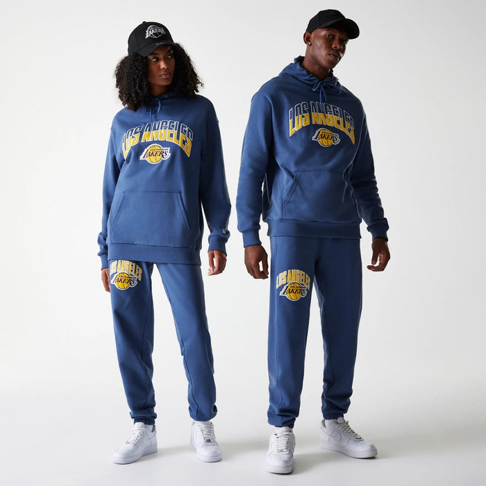 The Male model is wearing LA Lakers NBA Arch Graphic Dark Blue Joggers 1
