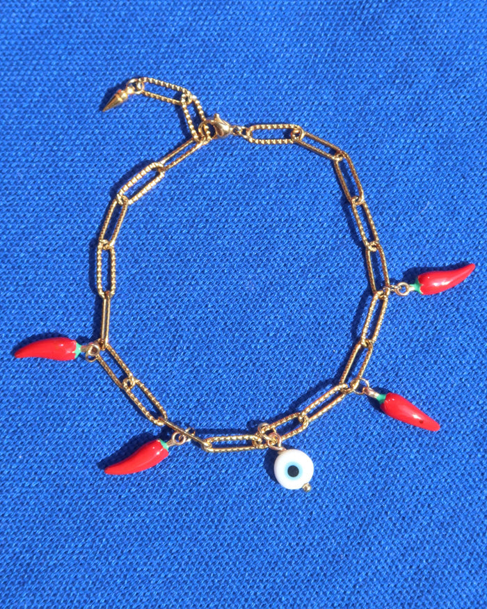 Gold paperclip chain bracelet with a white evil eye charm and red Italian cornicello charms for good luck, lucky charm bracelet made in Greece