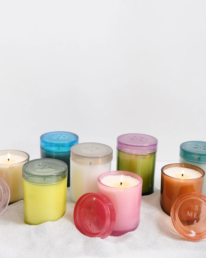 The MERSEA - SUMMER IN PROVENCE JOLIE JAR CANDLE by MERSEA features a green glass jar with a translucent pink lid, shown on a white background. Its smooth, cylindrical design makes it ideal for holding summer-inspired scents.
