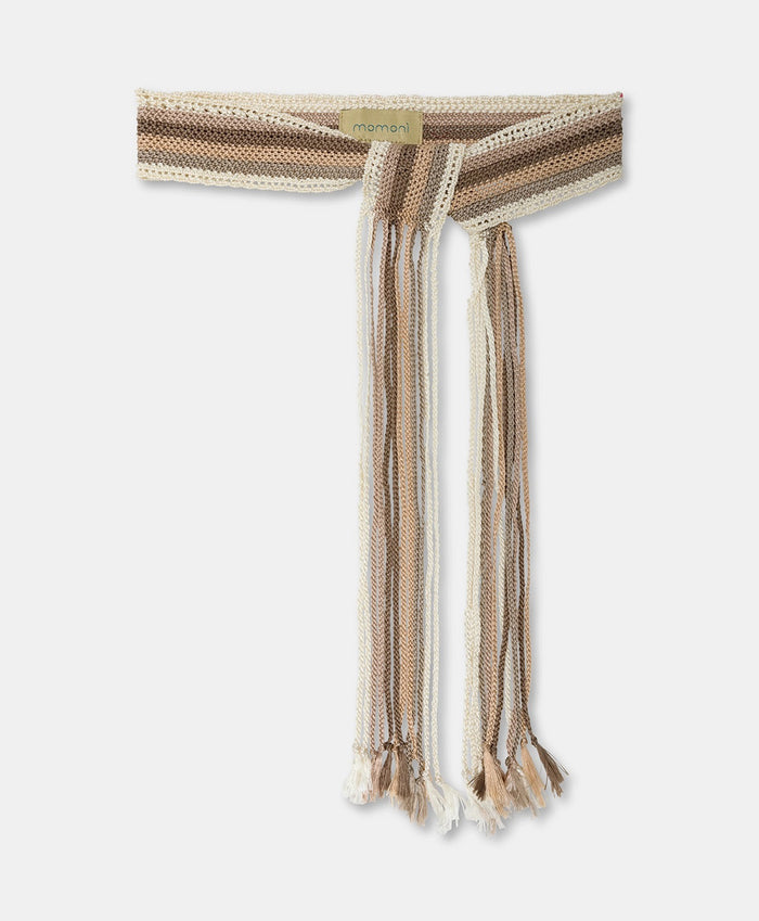 The MOMONI - JOSIE SASH BELT by MOMONI is a knitted accessory with braided maxi fringes in beige, cream, and brown shades. It features varying length fringes and a small label at the top.